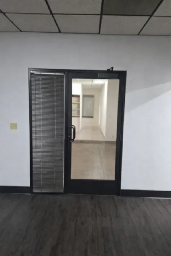 Commercial glass office door with aluminum frame and side panel, designed for corporate office environments and professional workspaces.